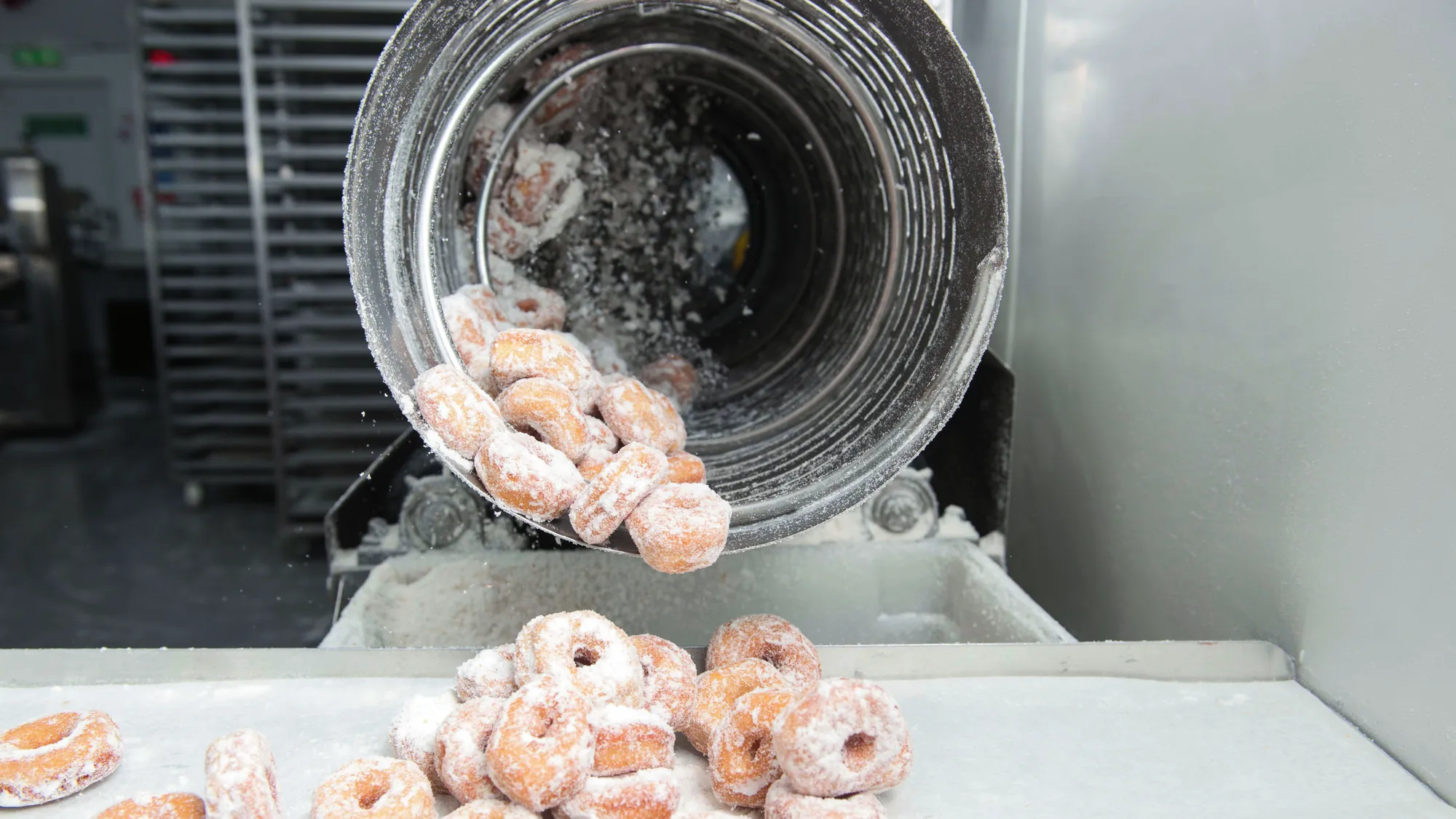 Mini ring doughnuts leaving the sugaring drum on the production line in Blackburn